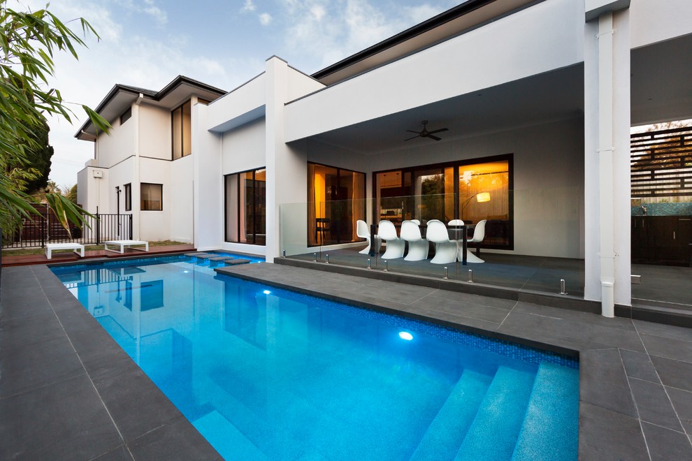 Foto de piscina alargada moderna grande en forma de L en patio trasero