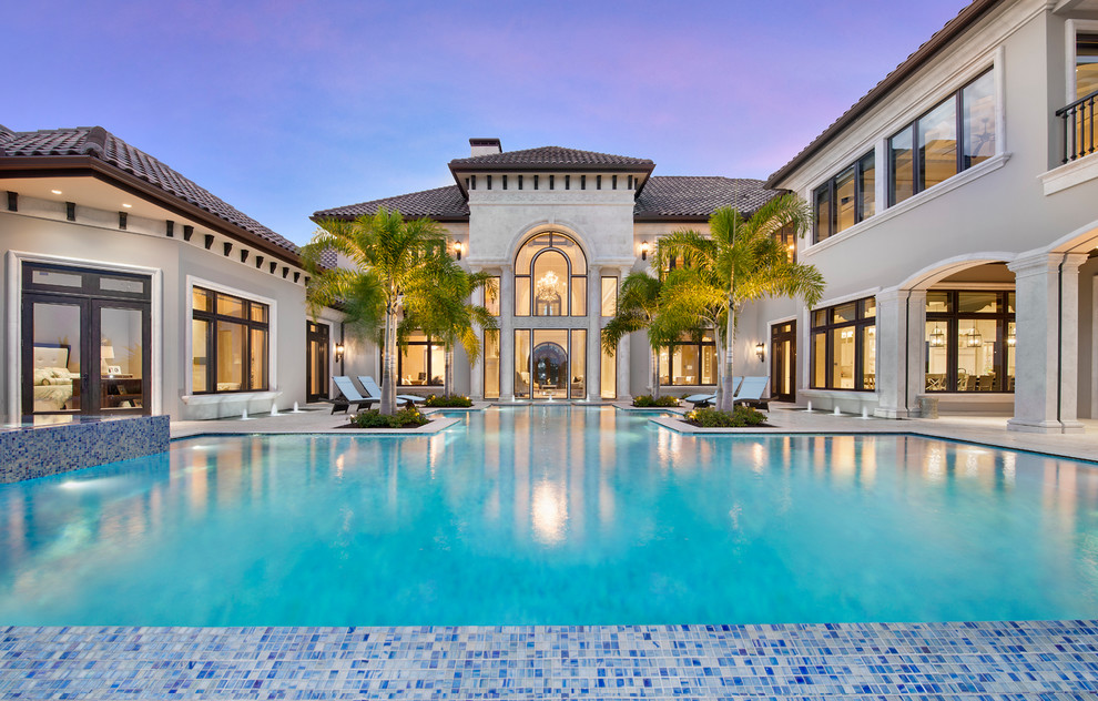 Geräumiger Klassischer Infinity-Pool hinter dem Haus in individueller Form mit Wasserspiel und Natursteinplatten in Miami