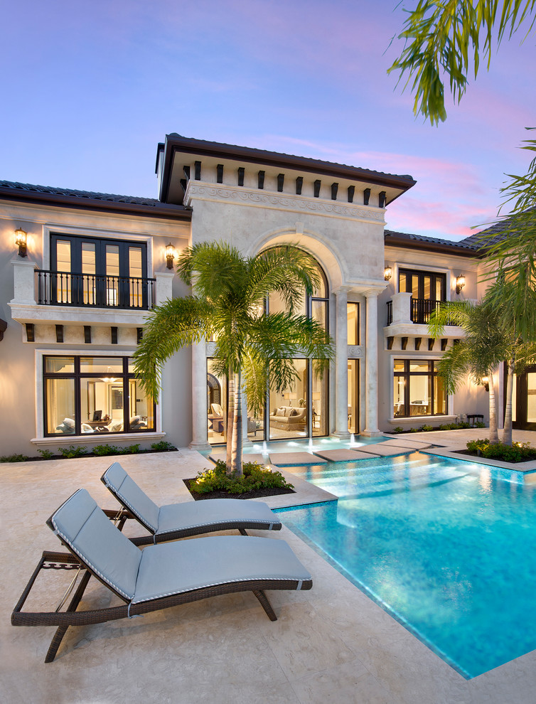 Geräumiger Klassischer Infinity-Pool hinter dem Haus in individueller Form mit Wasserspiel und Natursteinplatten in Miami