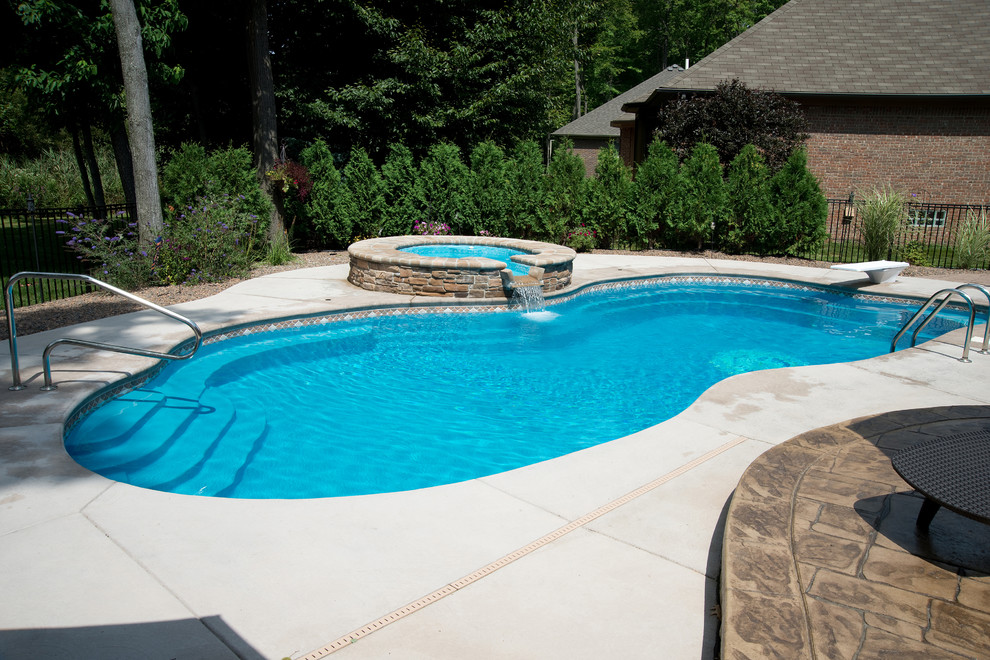 Inspiration for a large modern backyard concrete and custom-shaped pool remodel in Other