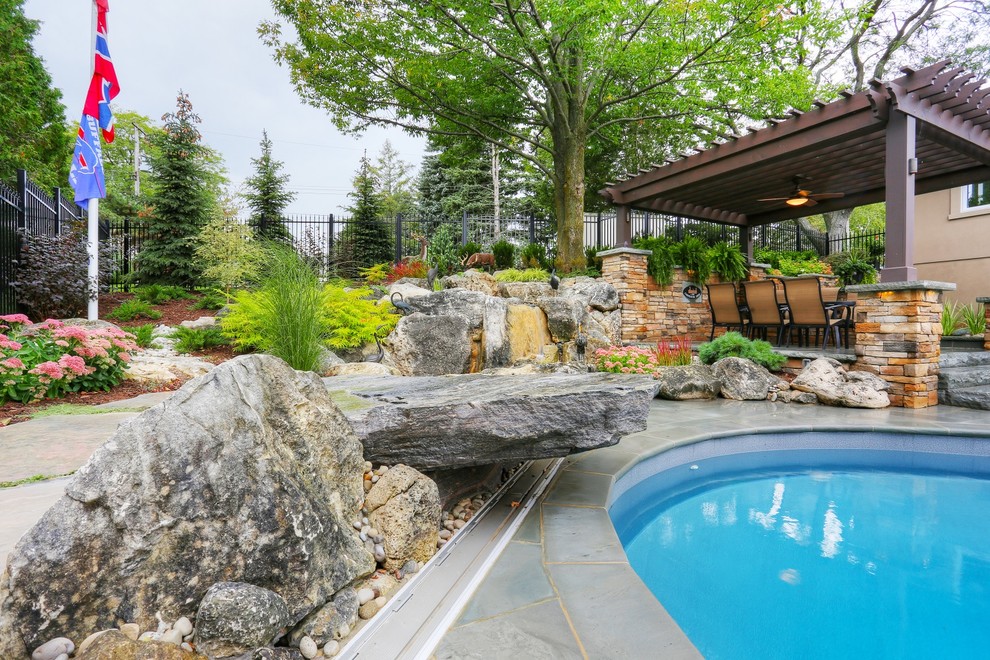 Идея дизайна: бассейн среднего размера на заднем дворе в стиле кантри с фонтаном и покрытием из каменной брусчатки