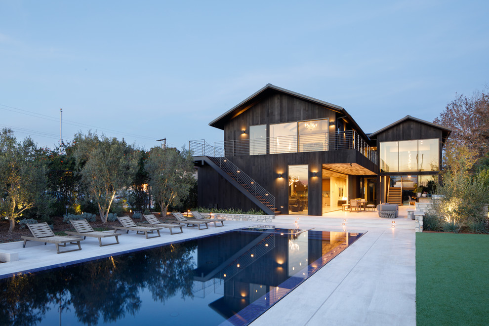 Idee per una piscina monocorsia minimal rettangolare dietro casa con lastre di cemento