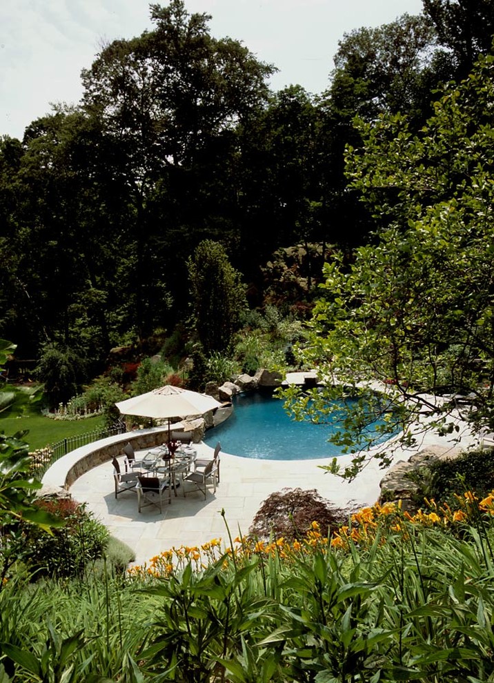 Example of a mid-sized backyard round natural hot tub design in New York