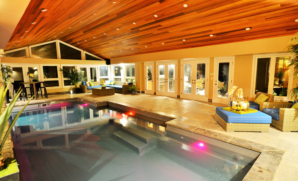 Ejemplo de casa de la piscina y piscina contemporánea de tamaño medio rectangular en patio trasero con adoquines de piedra natural