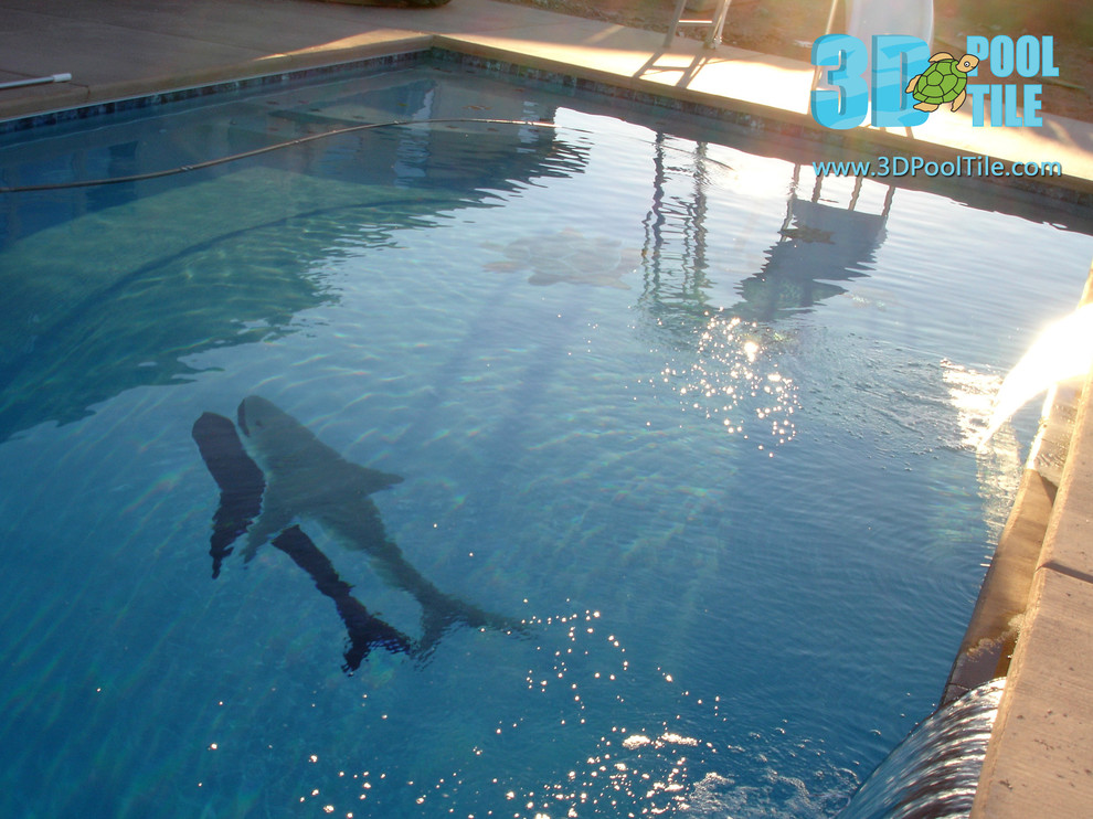 Immagine di una grande piscina monocorsia design rettangolare dietro casa con un acquascivolo e lastre di cemento