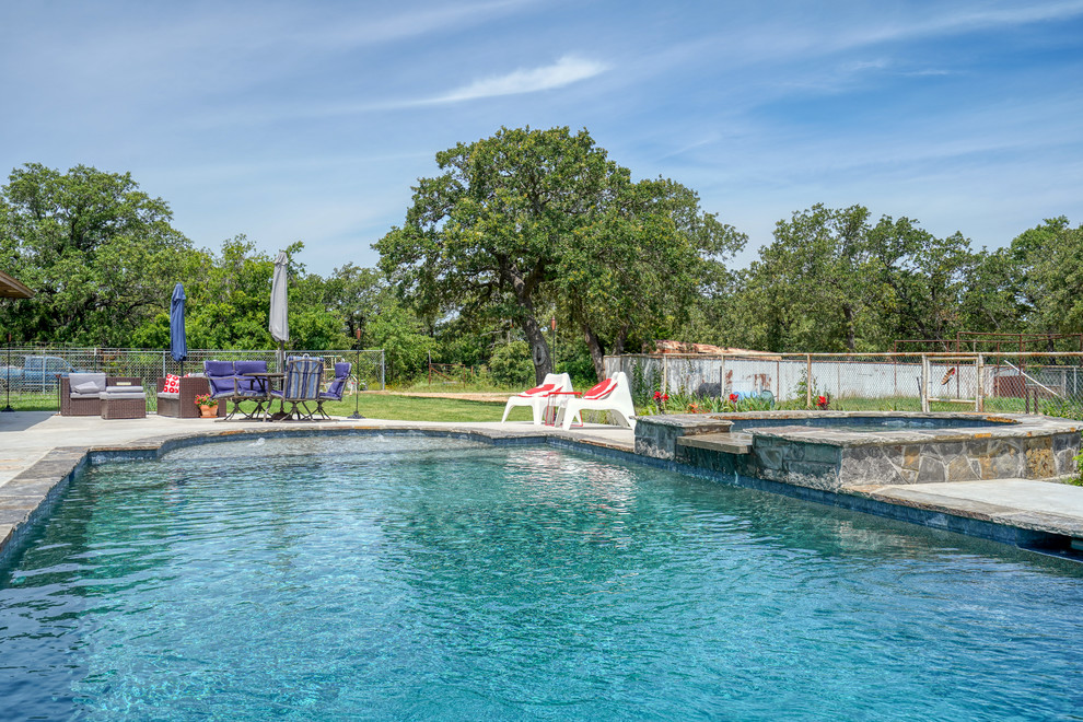 Ispirazione per una piscina vittoriana personalizzata di medie dimensioni e dietro casa con una vasca idromassaggio e lastre di cemento