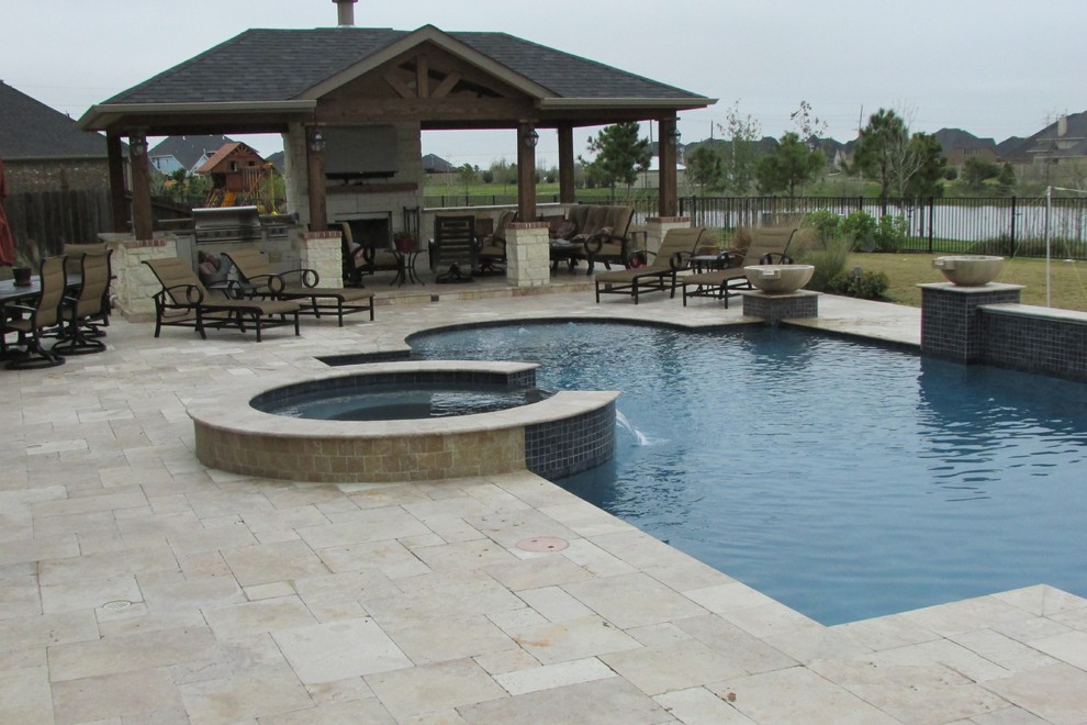 На фото: большой бассейн произвольной формы на заднем дворе в стиле рустика с джакузи и покрытием из каменной брусчатки с