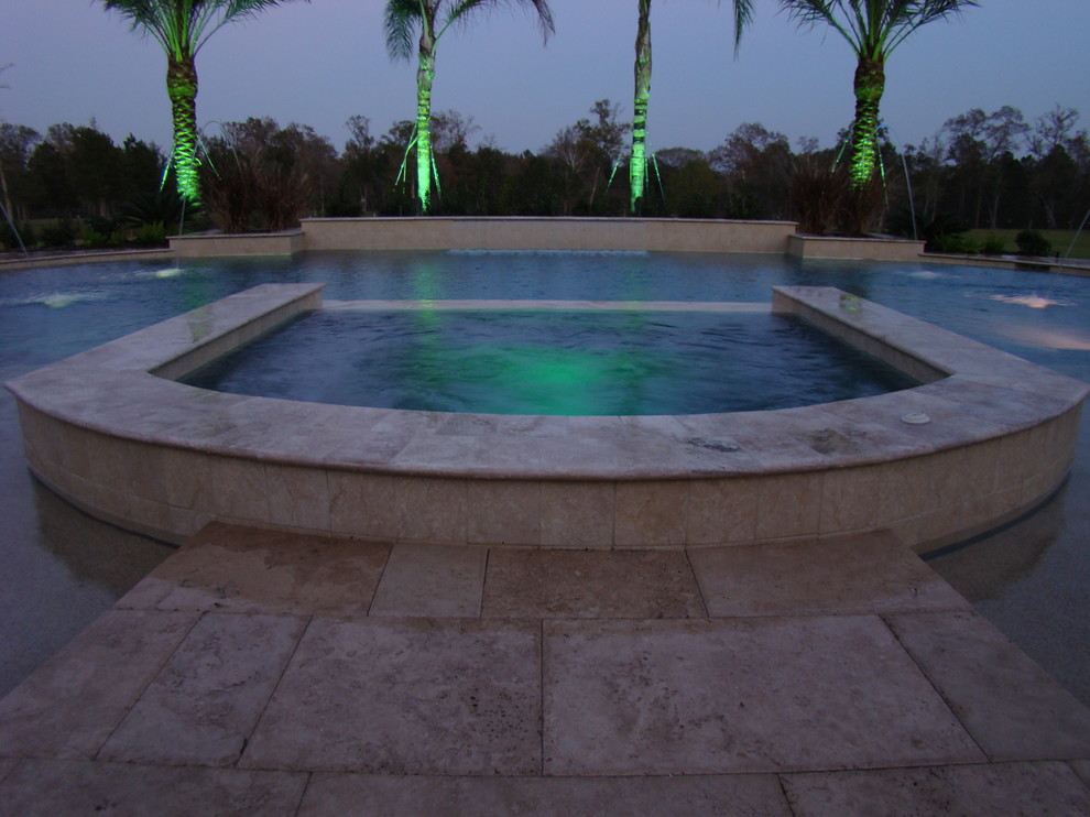 Ispirazione per una grande piscina mediterranea personalizzata dietro casa con una vasca idromassaggio e cemento stampato
