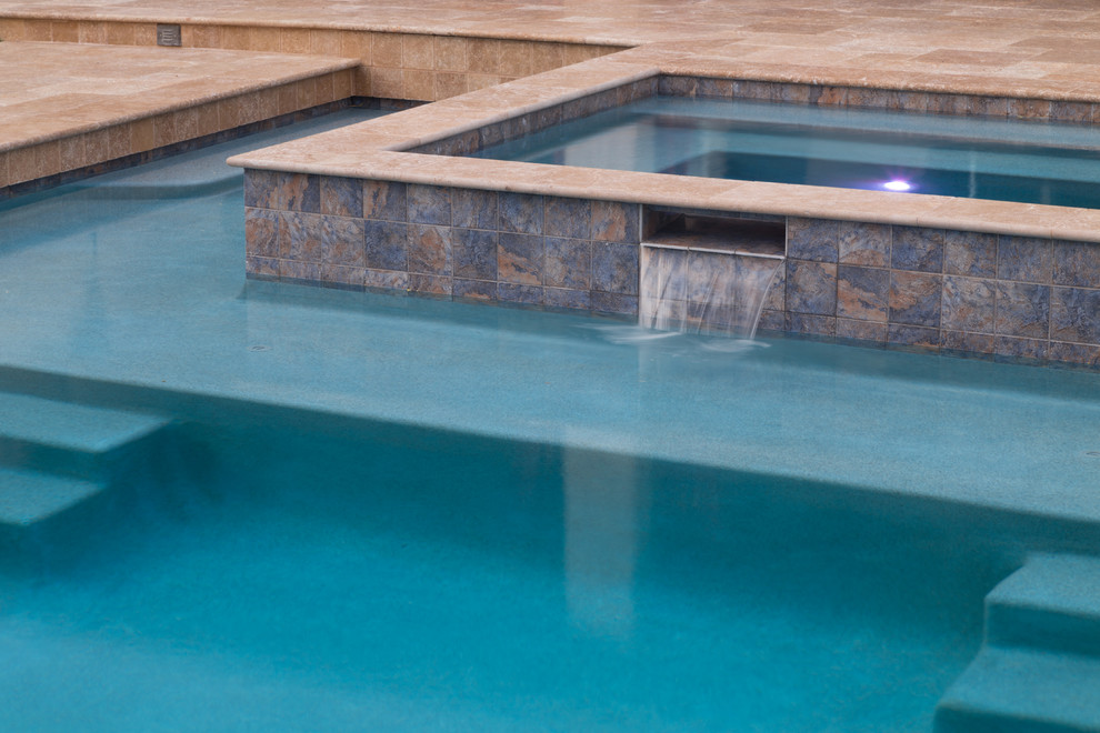 Ejemplo de piscina con fuente mediterránea grande a medida en patio trasero con suelo de baldosas