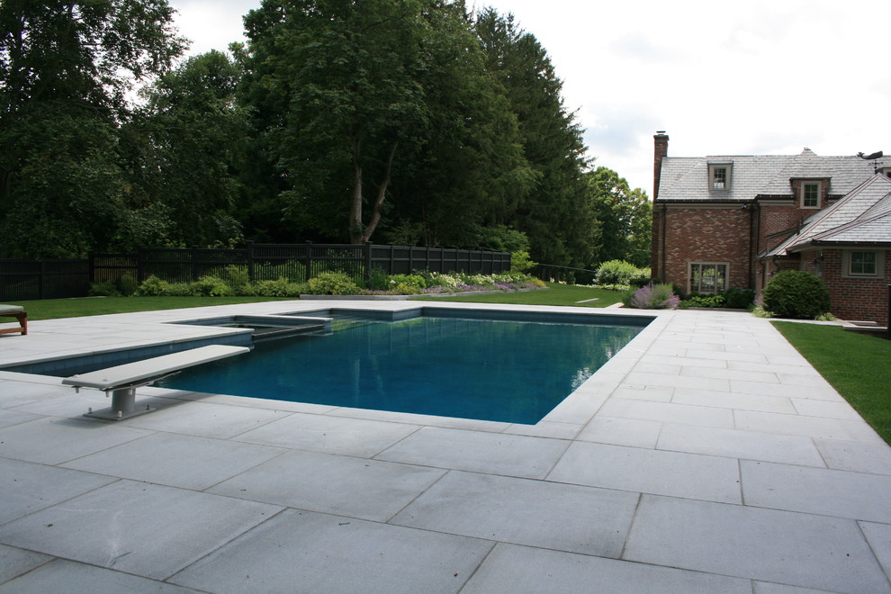 Пример оригинального дизайна: большой прямоугольный, спортивный бассейн на заднем дворе в классическом стиле с покрытием из декоративного бетона