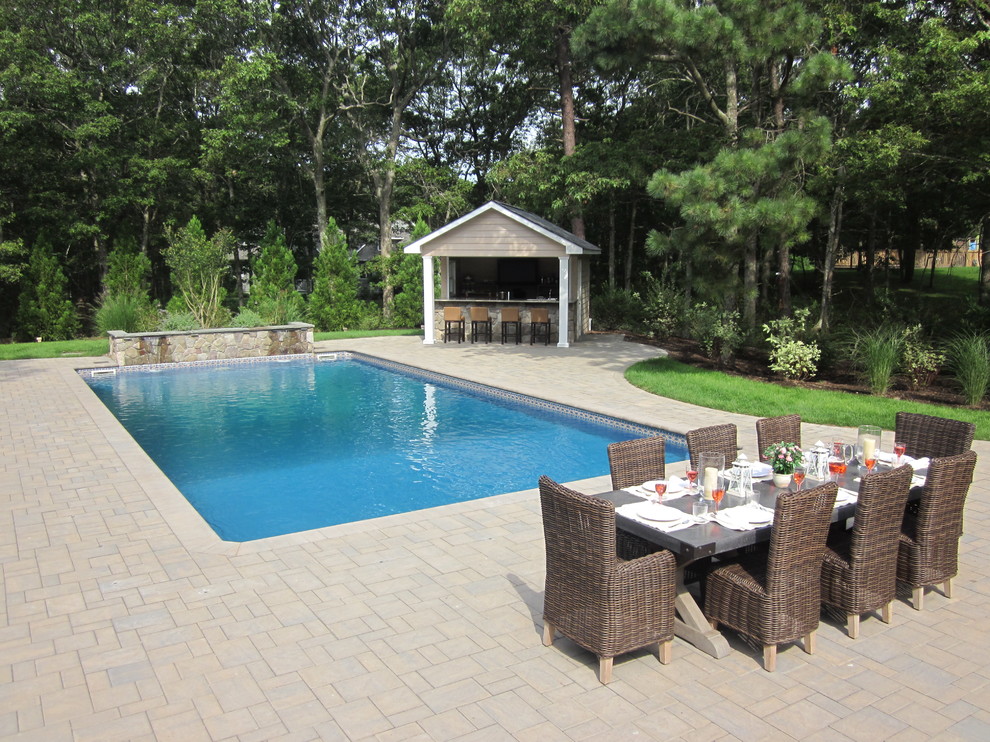 Diseño de piscinas y jacuzzis naturales clásicos de tamaño medio rectangulares en patio trasero con adoquines de hormigón