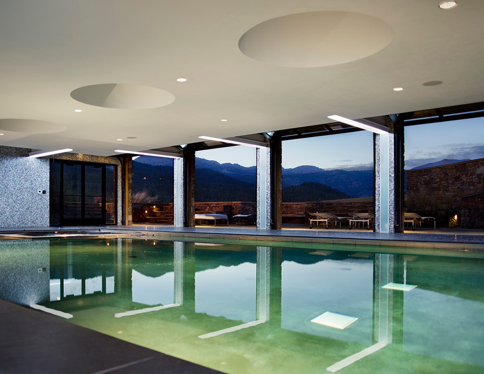 Foto di una grande piscina coperta minimal rettangolare con una dépendance a bordo piscina e lastre di cemento