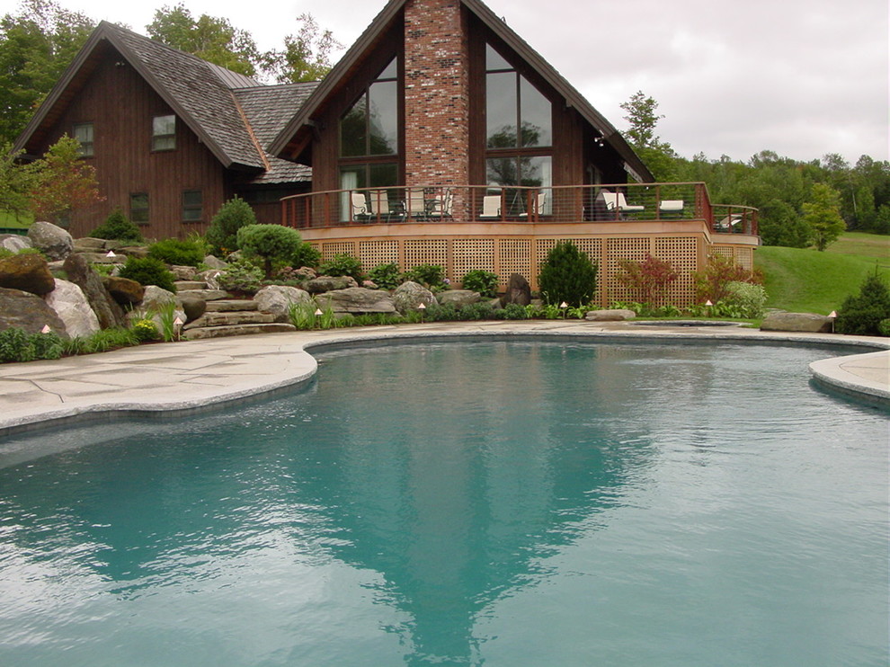 Foto de piscina infinita de estilo americano de tamaño medio a medida en patio trasero con adoquines de hormigón