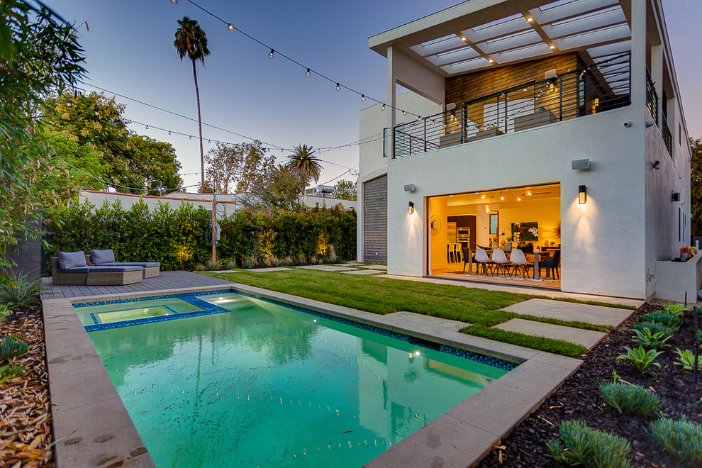 Foto di una piscina fuori terra minimalista rettangolare di medie dimensioni e dietro casa con una vasca idromassaggio e pedane
