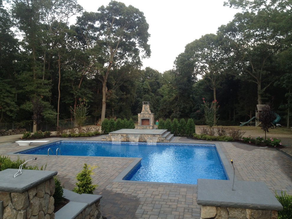 Immagine di una grande piscina monocorsia tradizionale rettangolare dietro casa con fontane e cemento stampato