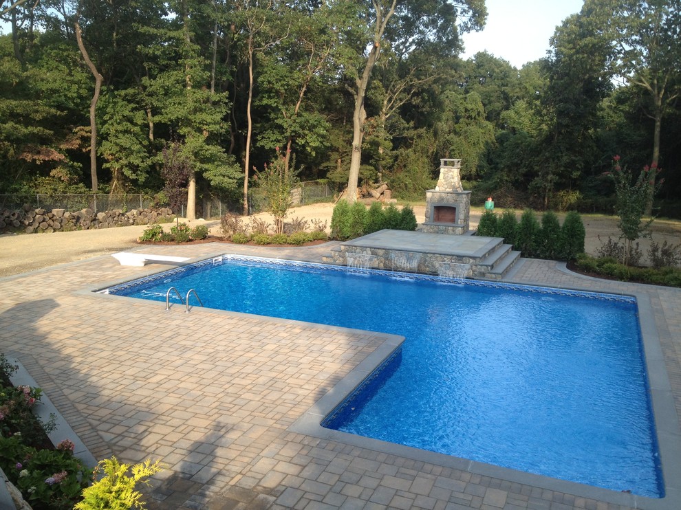 Immagine di una grande piscina monocorsia classica rettangolare dietro casa con fontane e cemento stampato