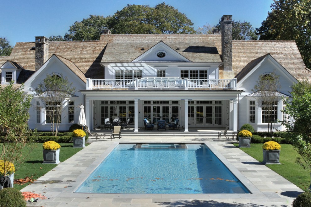 Idee per una grande piscina tradizionale rettangolare dietro casa con pavimentazioni in pietra naturale