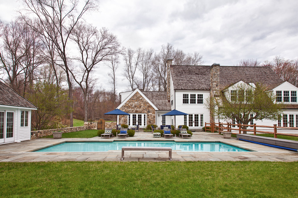 Modelo de casa de la piscina y piscina tradicional renovada extra grande rectangular en patio trasero con adoquines de piedra natural