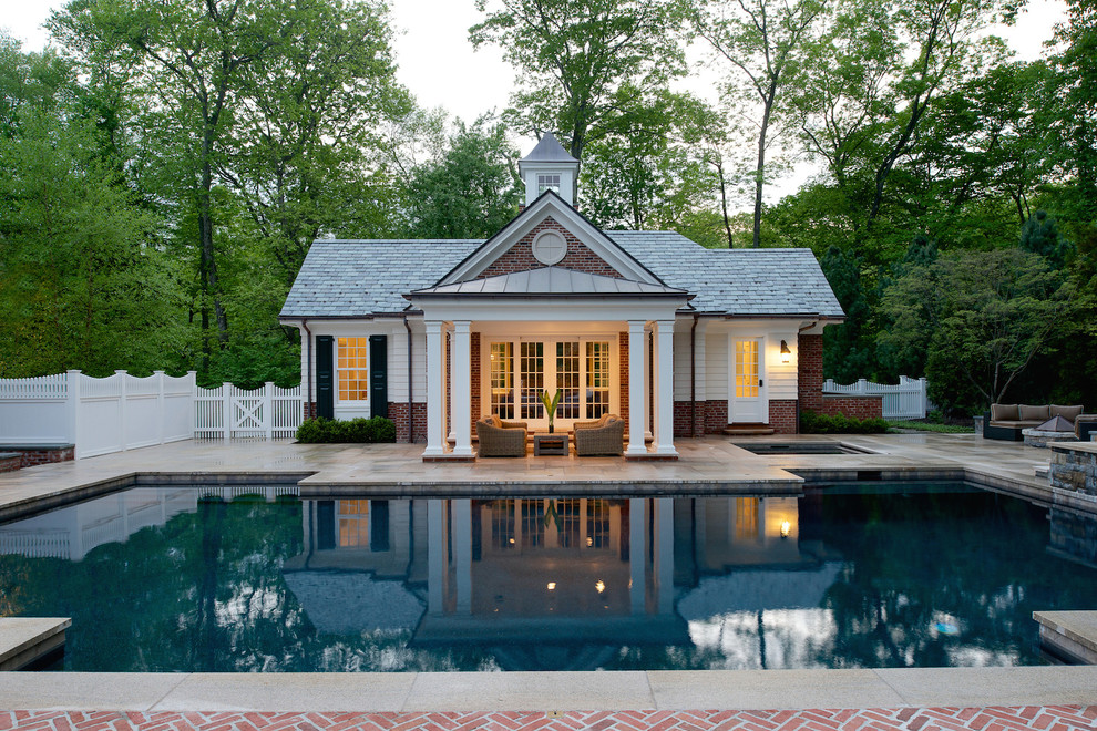 Photo of a traditional back custom shaped swimming pool in New York with a pool house.