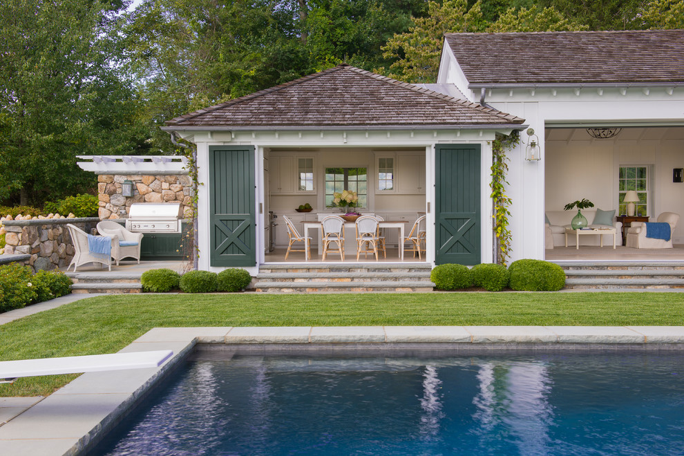 Large rural back rectangular lengths swimming pool in San Francisco with a pool house and tiled flooring.