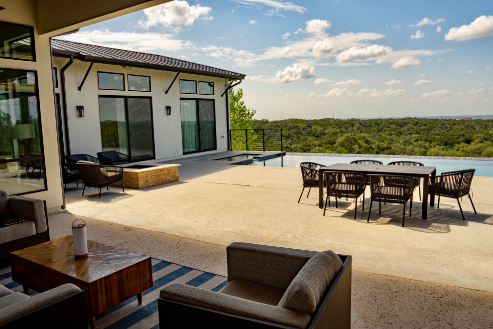 Inspiration for a huge modern backyard concrete and rectangular infinity and privacy pool remodel in Austin