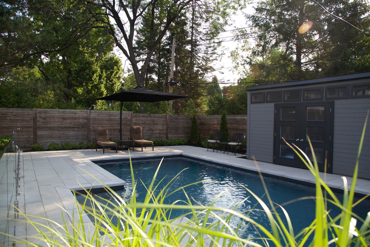 Esempio di una piscina personalizzata dietro casa con una dépendance a bordo piscina e pavimentazioni in cemento
