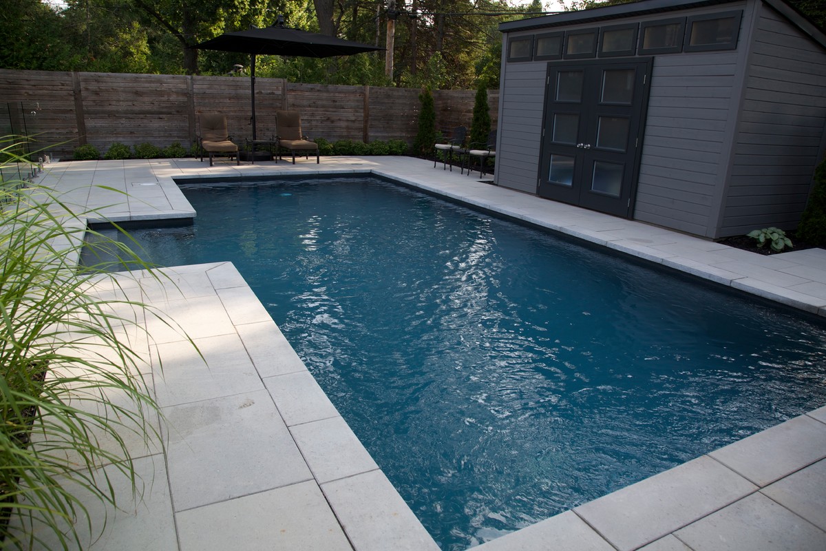 Immagine di una piscina personalizzata dietro casa con una dépendance a bordo piscina e pavimentazioni in cemento