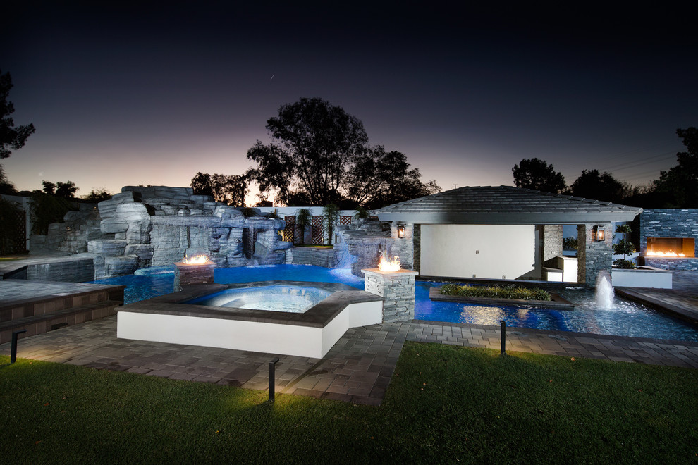 Esempio di una grande piscina minimal personalizzata dietro casa con una vasca idromassaggio e pavimentazioni in cemento