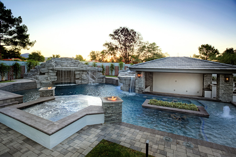 Foto på en stor funkis pool på baksidan av huset, med spabad och marksten i betong