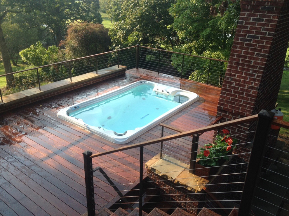 Example of a small rooftop rectangular natural hot tub design in Other