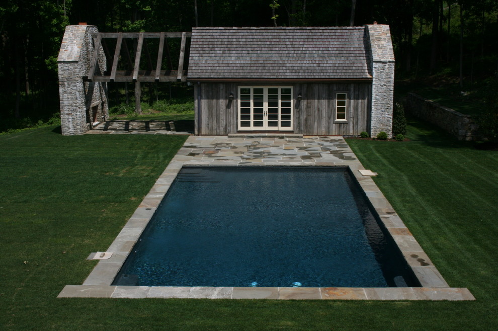 Immagine di una piscina rustica rettangolare di medie dimensioni e dietro casa con una dépendance a bordo piscina e pavimentazioni in pietra naturale