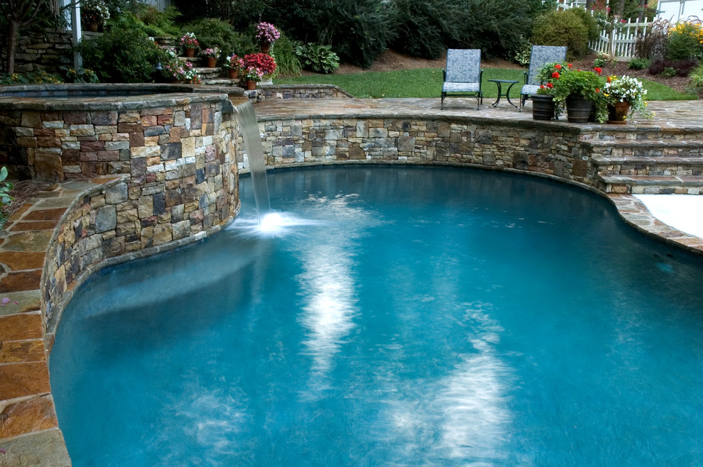 Idee per una piscina naturale classica personalizzata di medie dimensioni e dietro casa con una vasca idromassaggio e pavimentazioni in cemento