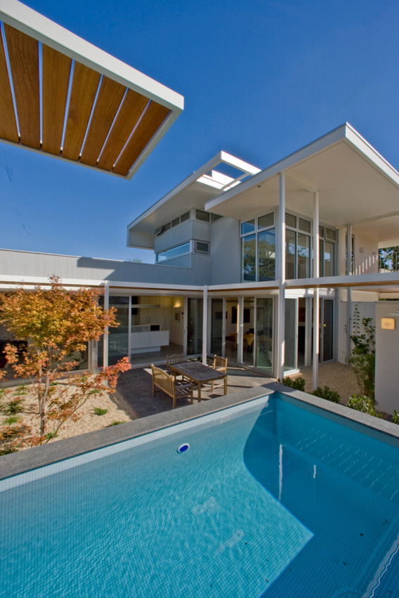 Idee per una piscina monocorsia moderna rettangolare di medie dimensioni e dietro casa con ghiaia