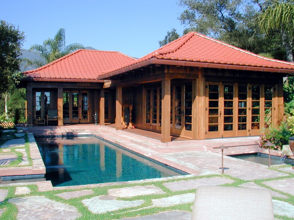 Exempel på en mellanstor asiatisk rektangulär träningspool på baksidan av huset, med spabad och naturstensplattor