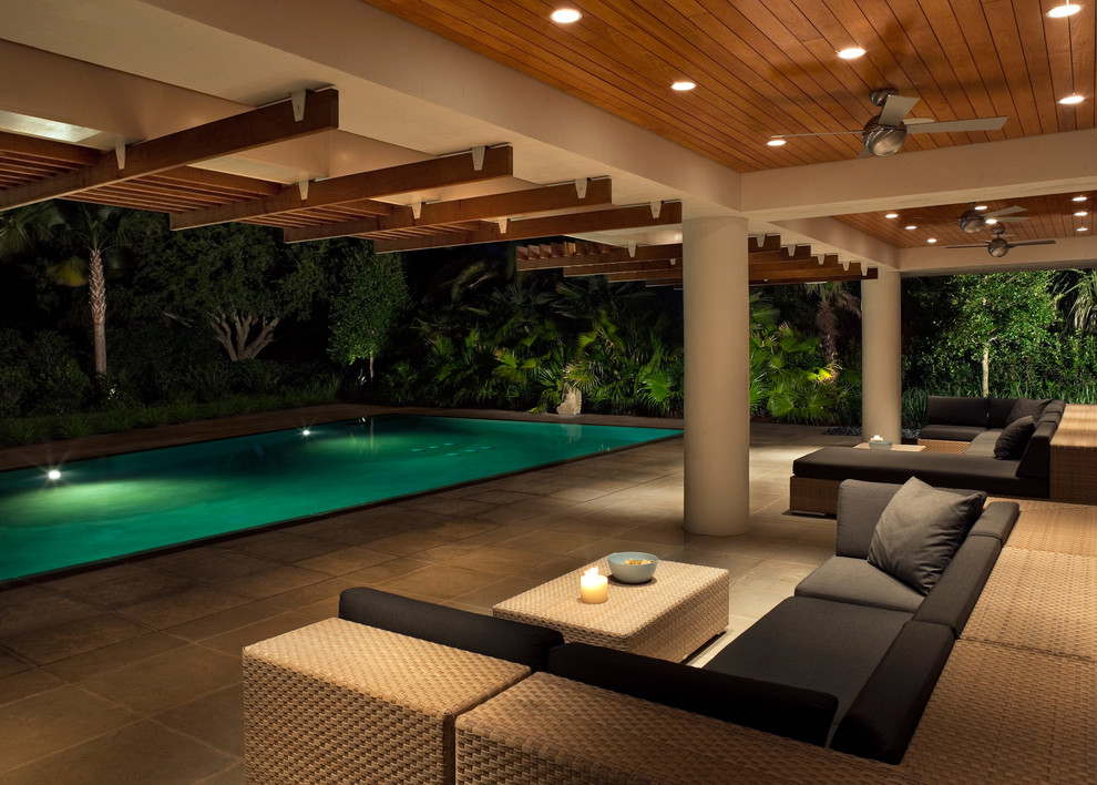 Modelo de piscina exótica pequeña rectangular en patio trasero con adoquines de piedra natural