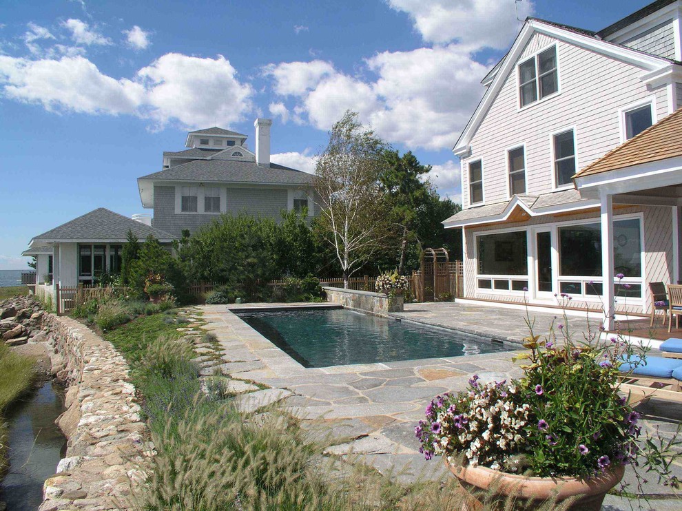 Esempio di una piscina monocorsia costiera rettangolare dietro casa e di medie dimensioni con fontane e pavimentazioni in pietra naturale