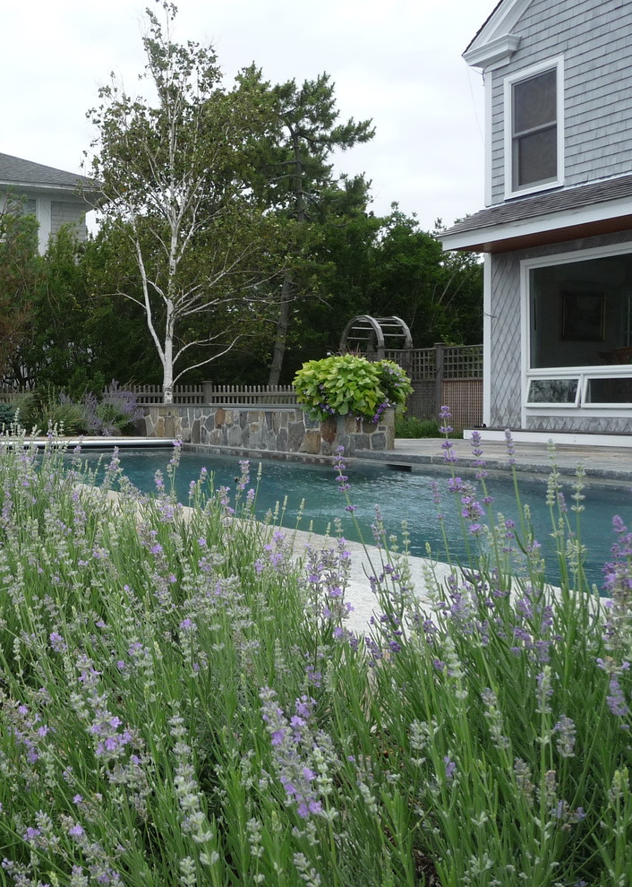 Maritimer Pool hinter dem Haus in rechteckiger Form mit Wasserspiel und Natursteinplatten in Bridgeport