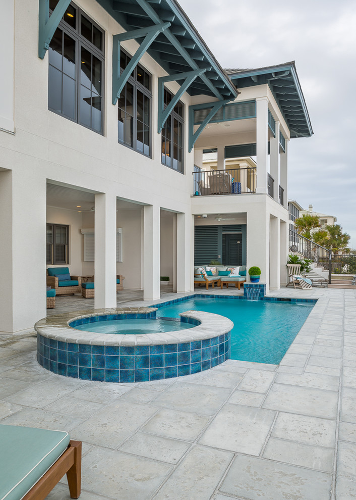 Foto di una piscina naturale stile marino rettangolare di medie dimensioni e dietro casa con una vasca idromassaggio e pavimentazioni in cemento