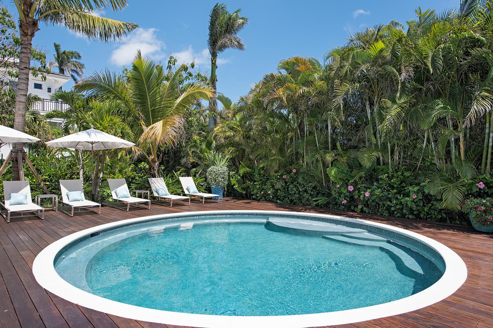 Foto de piscina exótica redondeada con entablado