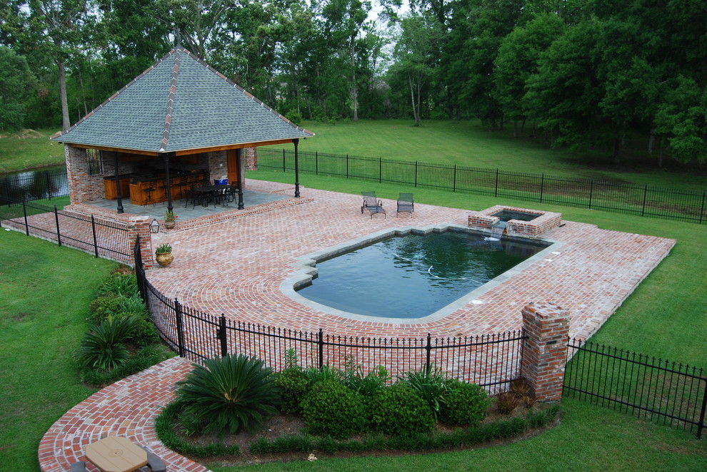 Inspiration for a world-inspired back rectangular swimming pool in New Orleans with a pool house and brick paving.