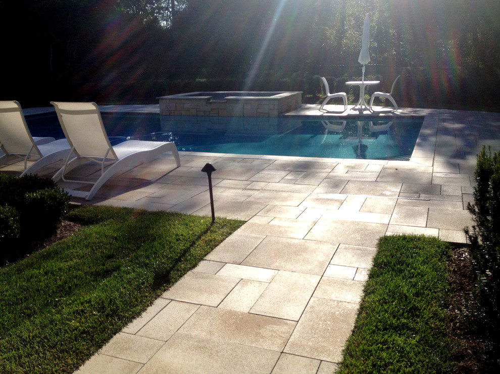 Foto di una piscina contemporanea personalizzata dietro casa con pavimentazioni in mattoni e una vasca idromassaggio