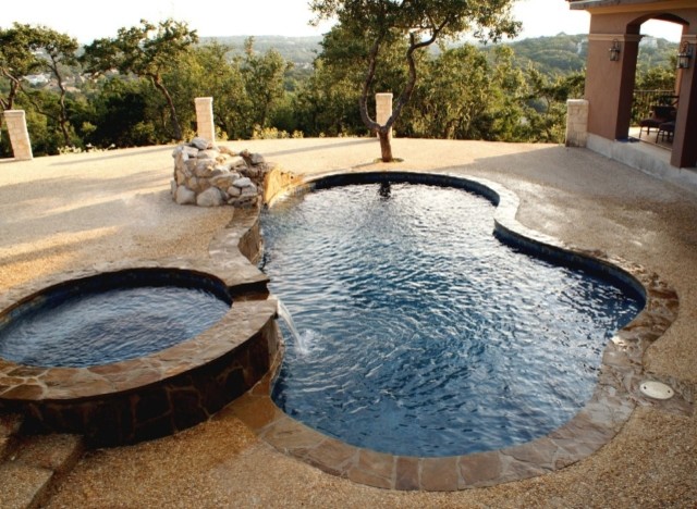 Idee per una piscina classica personalizzata dietro casa con una vasca idromassaggio e cemento stampato