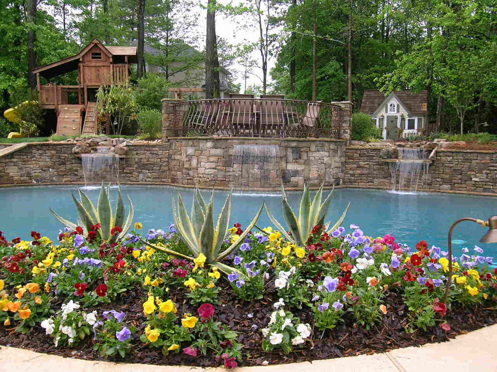 Foto de piscina con fuente natural clásica grande a medida en patio trasero con adoquines de piedra natural