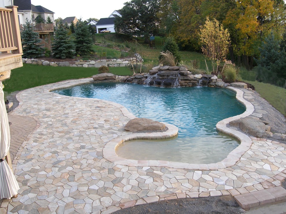 Modelo de piscinas y jacuzzis infinitos de estilo americano grandes a medida en patio trasero con adoquines de hormigón