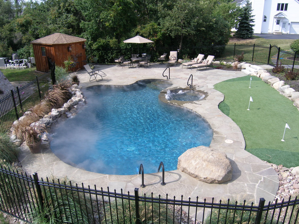 Foto de piscina grande con suelo de hormigón estampado