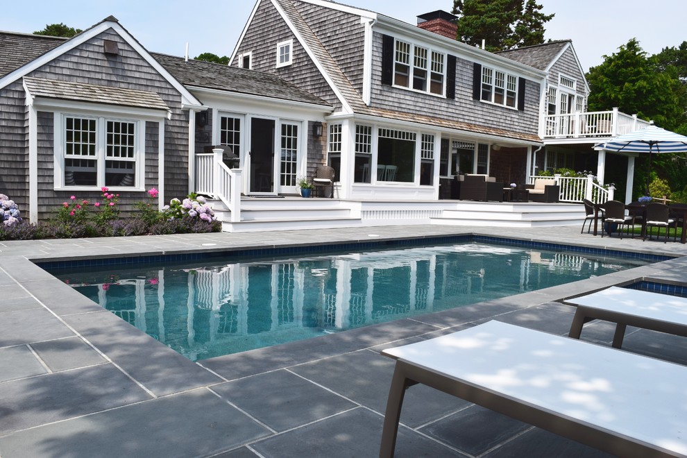 Foto de piscina alargada costera de tamaño medio rectangular en patio trasero con suelo de baldosas