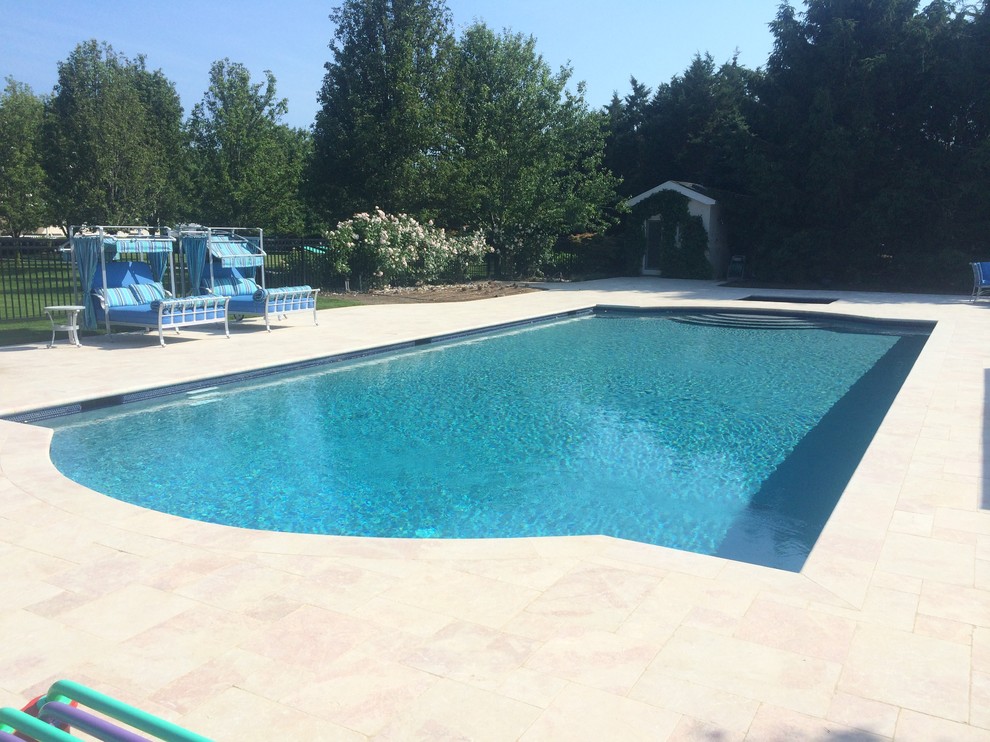 Imagen de piscina minimalista grande rectangular en patio trasero con adoquines de piedra natural