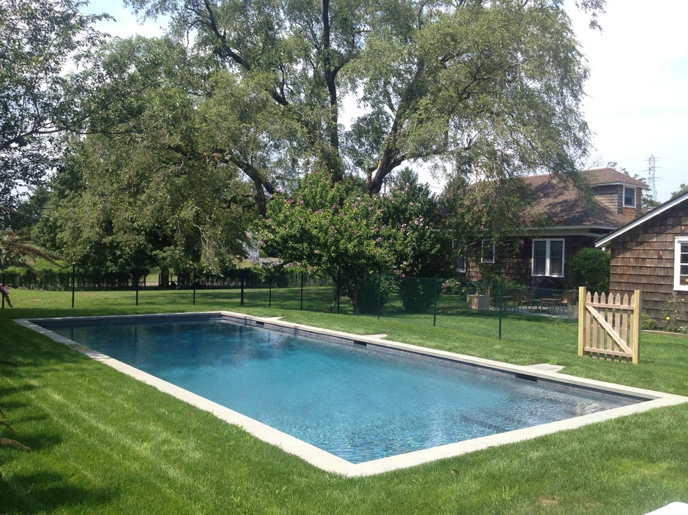 Modelo de piscina minimalista de tamaño medio rectangular en patio trasero con adoquines de piedra natural