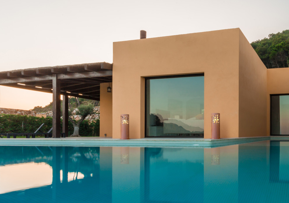 Imagen de casa de la piscina y piscina elevada mediterránea de tamaño medio a medida en patio delantero con suelo de baldosas