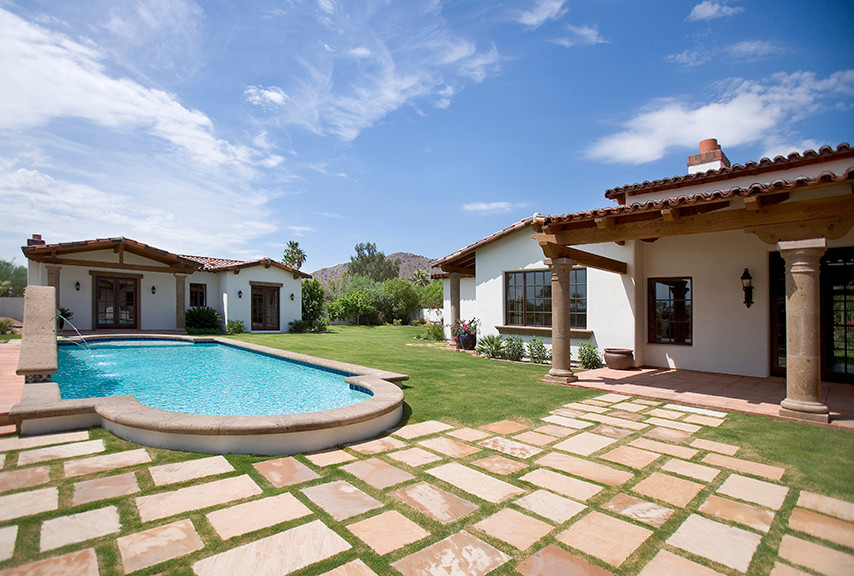 Large tuscan backyard concrete and custom-shaped pool house photo in Phoenix